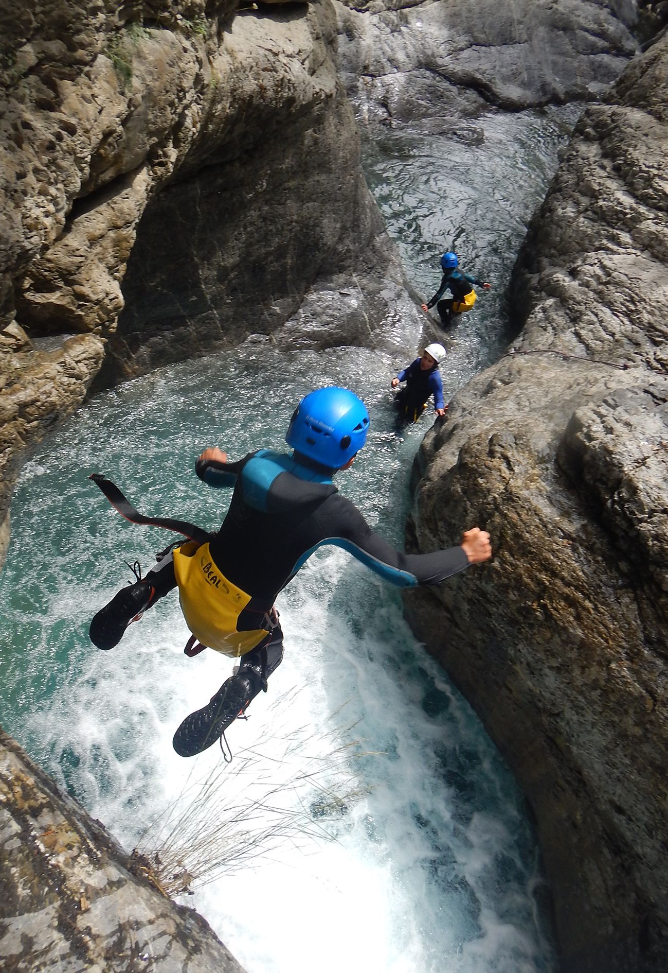 L'image représente un enfant qui saute dans l'eau en canyoning